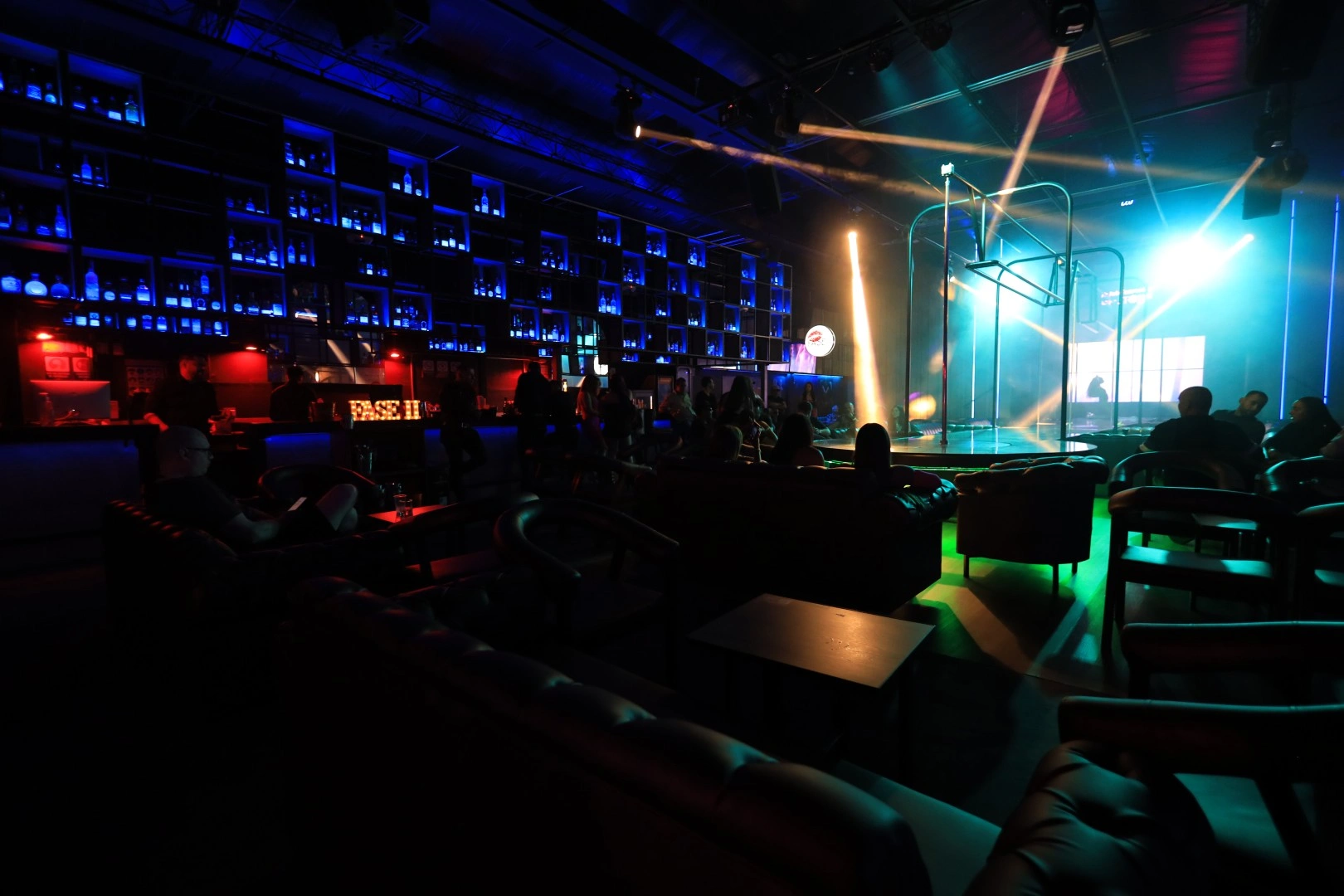 Interior del Club Fase II en Medellín con luces de neón y ambiente nocturno seguro